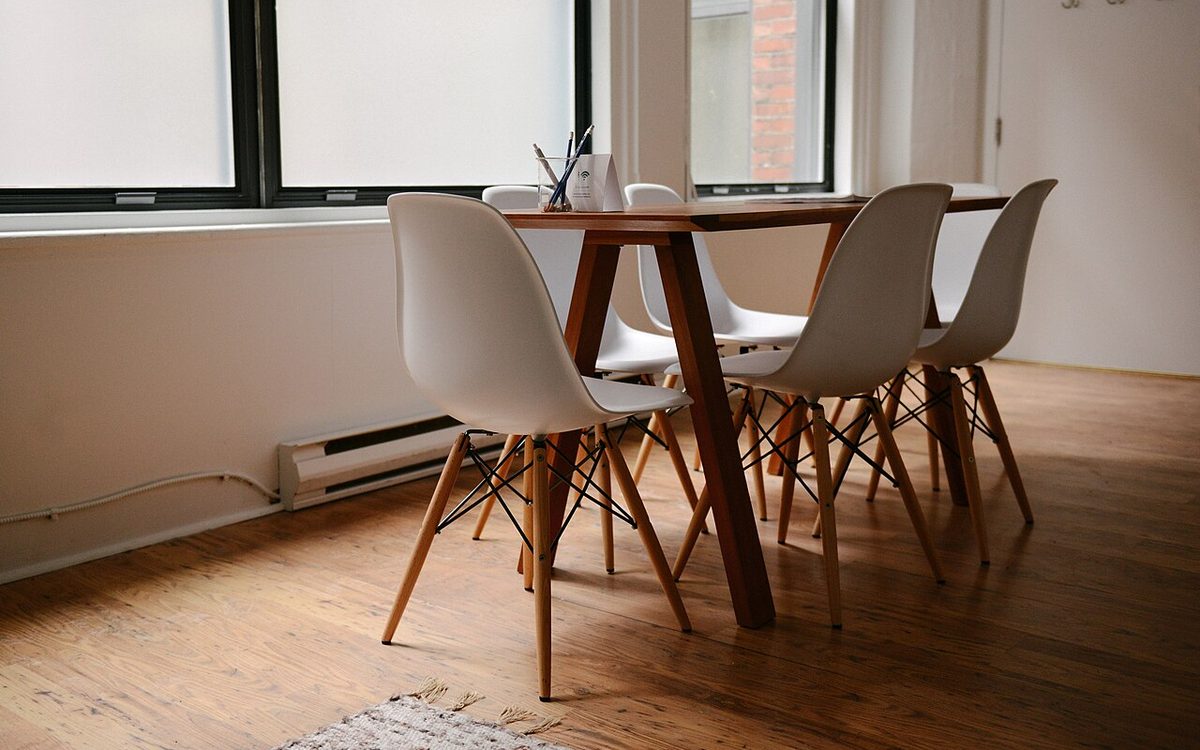 Wooden table and chairs in a bright, empty meeting room